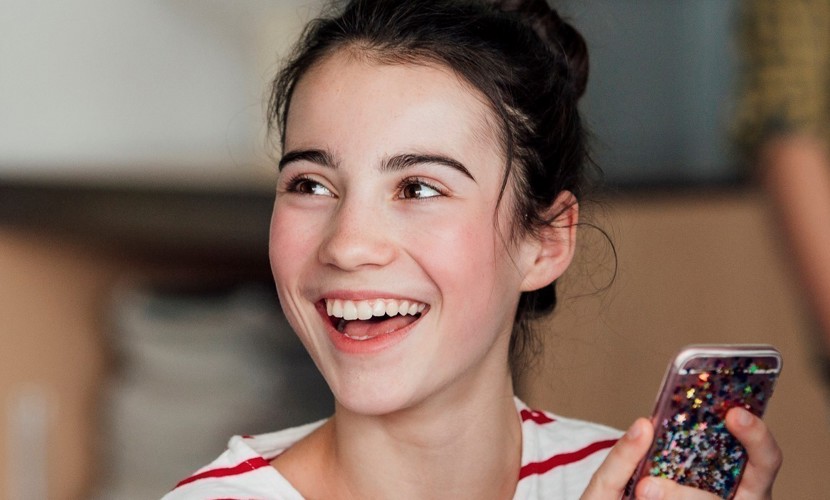 Smiling girl whilst using her phone