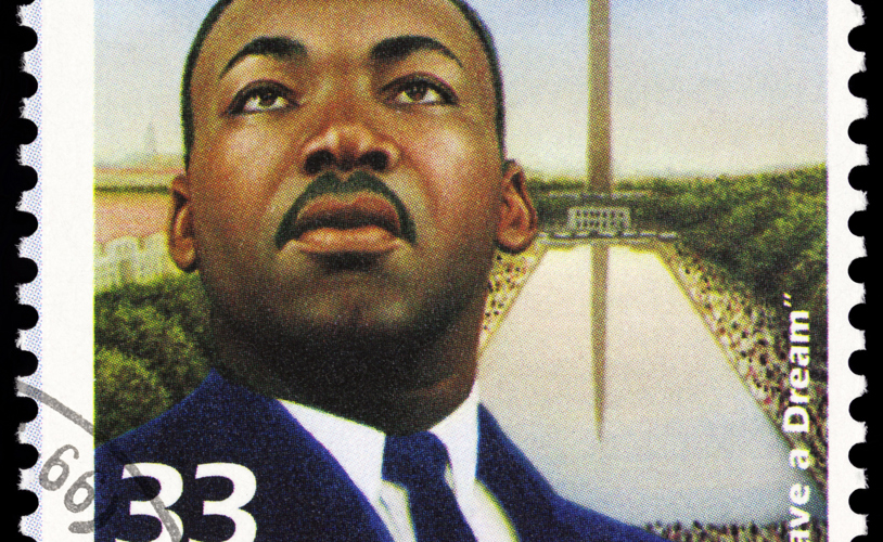 A 1999 USA postage stamp. Martin Luther King Jr is depicted wearing a badge that reads: MARCH ON WASHINGTON FOR JOBS & FREEDOM, and in the background is the Washington Memorial and a large crowd of people. The stamp commemorates the August 28, 1963 demonstration in Washington, D.C.